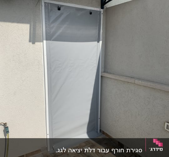 סוכך אפור תלוי על קיר חיצוני